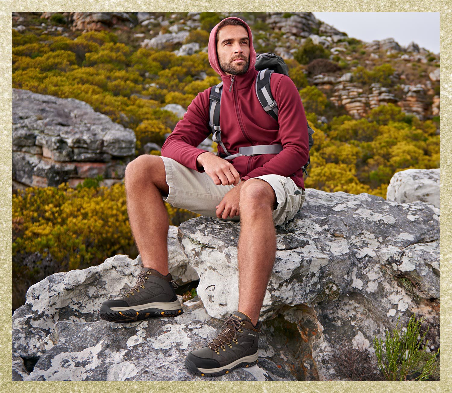 Man sitting on a rock with Skechers hiking boots