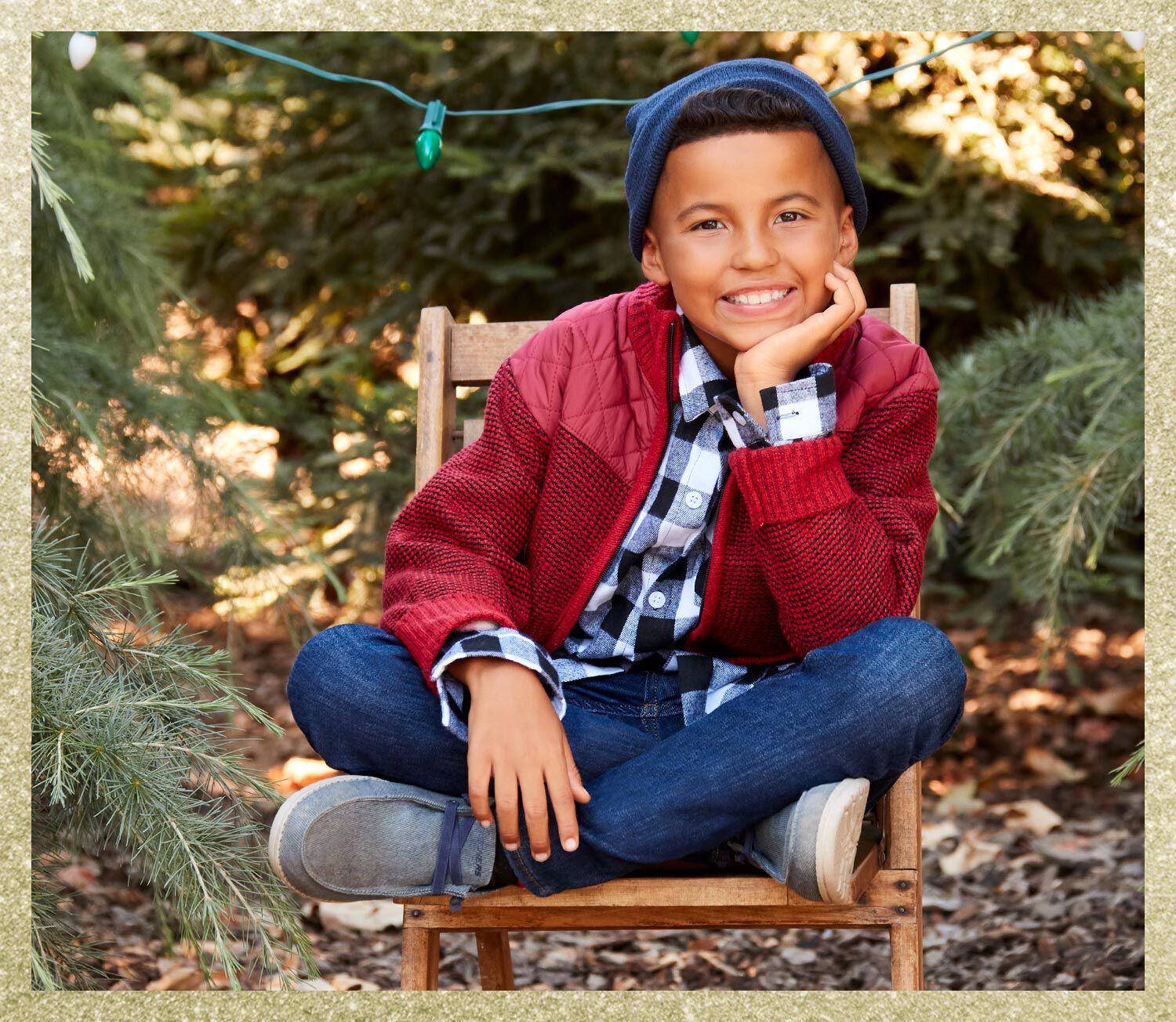 Boy smiling, sitting on a chair wearing Skechers shoes